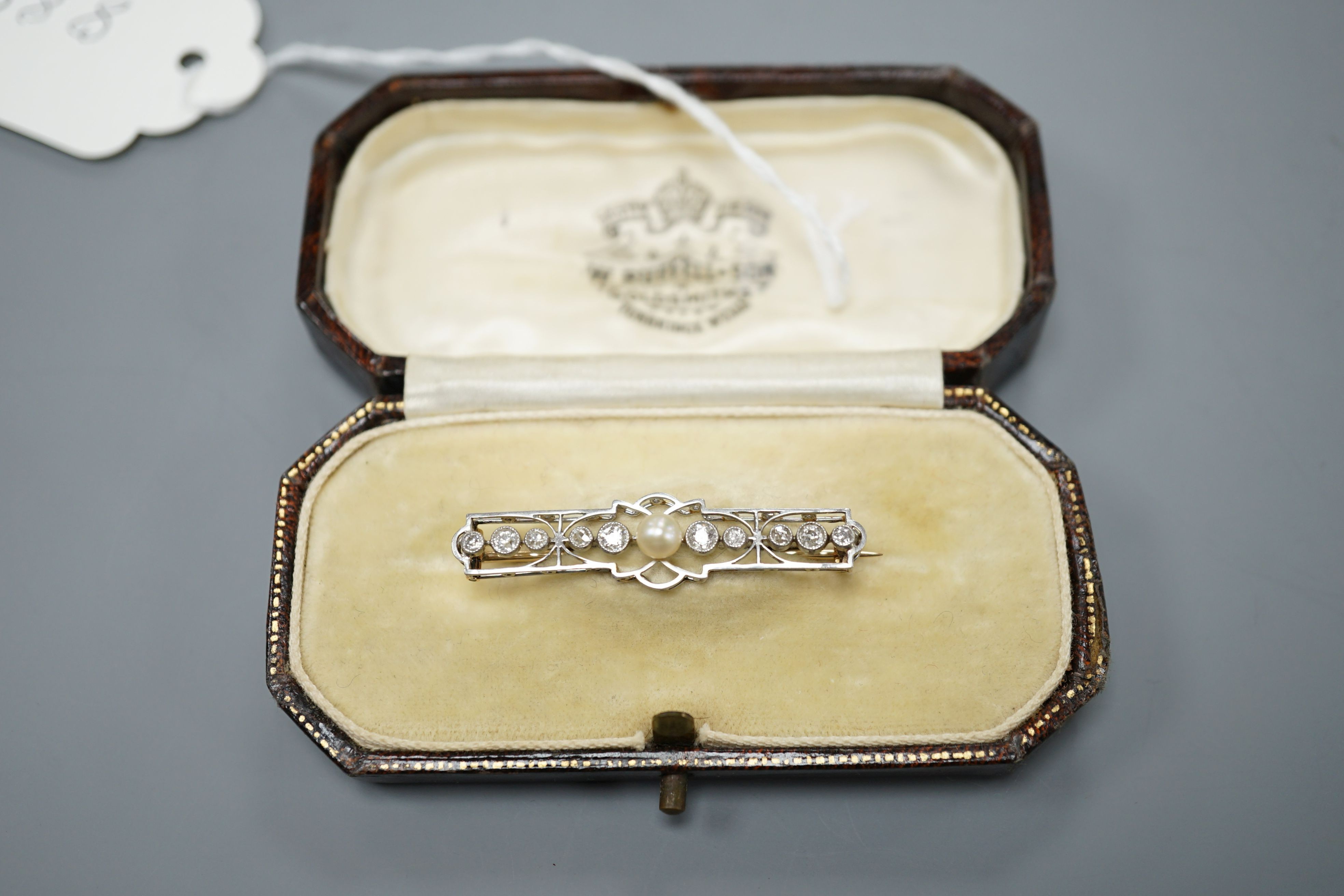 An early 20th century, yellow and white meta, cultured pearl and diamond set open work bar brooch, 41mm, gross weight 3.6 grams.